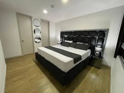 a bedroom with a large bed with a black headboard at Urban studios luxurious apartment in the poblado in Medellín