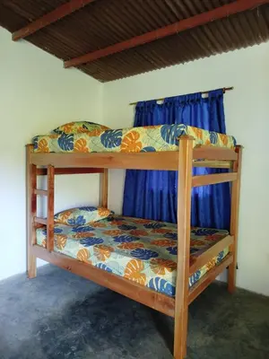 two bunk beds in a room with blue curtains at Finca el Eden in San Luis