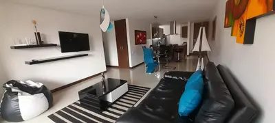 a living room with a black leather couch and a television at Lujoso y Economico Apartamento in Envigado