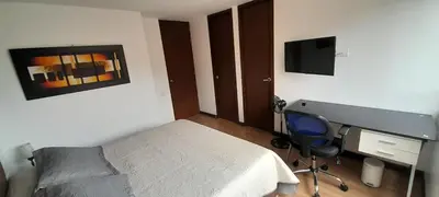 a bedroom with a bed and a desk and a television at Lujoso y Economico Apartamento in Envigado