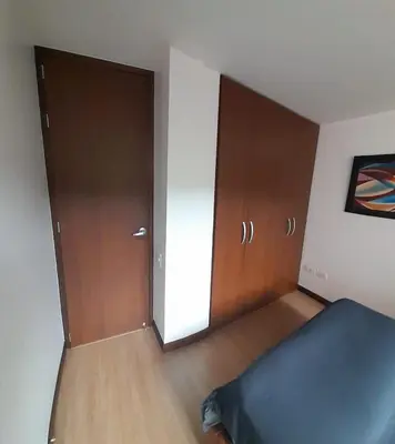 a bedroom with a bed and wooden cabinets and a door at Lujoso y Economico Apartamento in Envigado