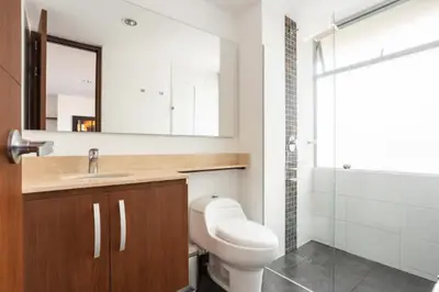 a bathroom with a toilet and a sink and a mirror at Lujoso y Economico Apartamento in Envigado