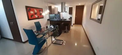 a room with a glass table and blue chairs at Lujoso y Economico Apartamento in Envigado