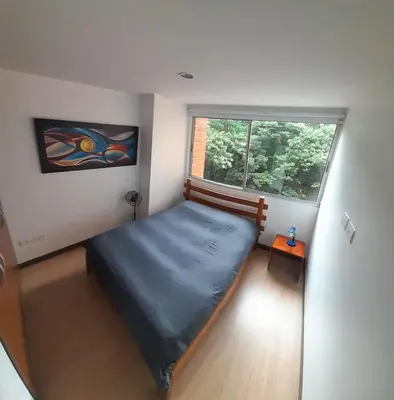 a bedroom with a bed in a room with a window at Lujoso y Economico Apartamento in Envigado