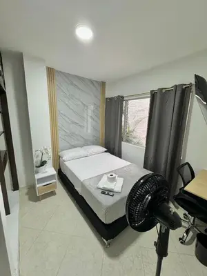 a bedroom with a bed and a desk and a window at Verde Primavera in Guayaquil