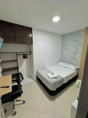 a bedroom with a bed and a desk and a chair at Verde Primavera in Guayaquil