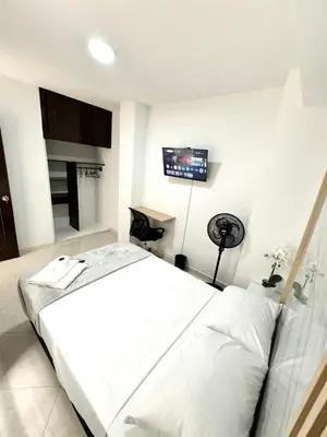 a bedroom with a bed and a tv on the wall at Verde Primavera in Guayaquil