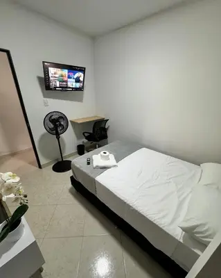 a bedroom with a bed and a flat screen tv at Verde Primavera in Guayaquil