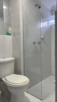 a bathroom with a toilet and a glass shower at Hotel Medellín 66 in Medellín