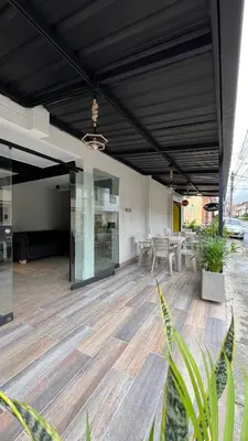 a large room with a table and chairs on a wooden floor at Hotel Medellín 66 in Medellín