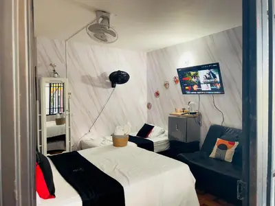 a bedroom with a bed and two chairs and a television at Habitacion ,Aire, Netflix cerca Santorini in Doradal