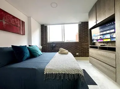 a bedroom with a large bed with a television at El Tesoro Apto in Poblado in El Poblado
