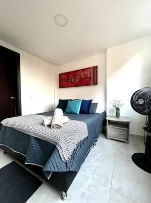 a bedroom with a large bed with blue pillows at El Tesoro Apto in Poblado in El Poblado