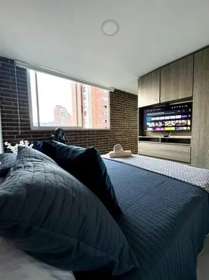 a bedroom with a large bed with a television on the wall at El Tesoro Apto in Poblado in El Poblado