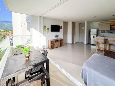 a living room with a table and a kitchen at Mountain View Pool & Slide AC 5min to Town in Santa Fe de Antioquia
