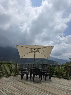 a table and chairs with an umbrella on a deck at Sedonascapes in Palmitas