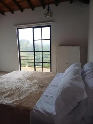 a bedroom with a large bed with a large window at Sedonascapes in Palmitas