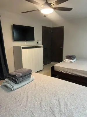 a bedroom with two beds and a flat screen tv at Apartamento Luxury Luxury apt in Medellín