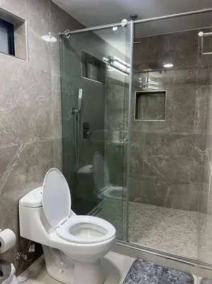 a bathroom with a toilet and a glass shower at Apartamento Luxury Luxury apt in Medellín