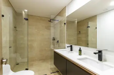 a bathroom with two sinks and a glass shower at Forever W&L Apartments in El Poblado