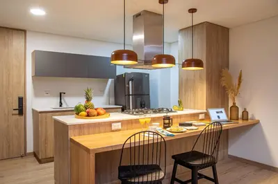 a kitchen with a counter with two chairs and a table at Forever W&L Apartments in El Poblado