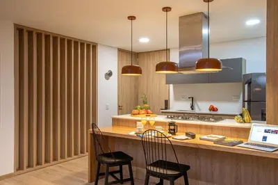 a kitchen with a counter with two chairs and aaptop at Forever W&L Apartments in El Poblado