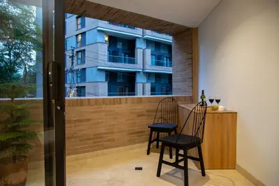 a balcony with two chairs and a table and a building at Forever W&L Apartments in El Poblado