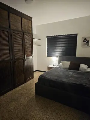 a bedroom with a bed and a large wooden cabinet at Casa luz in Medellín