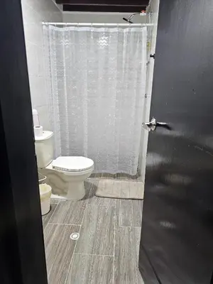a bathroom with a toilet and a shower curtain at Casa luz in Medellín