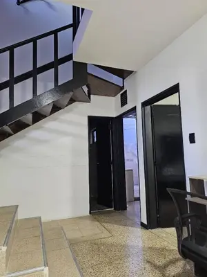 a room with two black doors and a staircase at Casa luz in Medellín