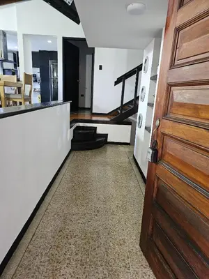 a room with a wooden door and a staircase at Casa luz in Medellín