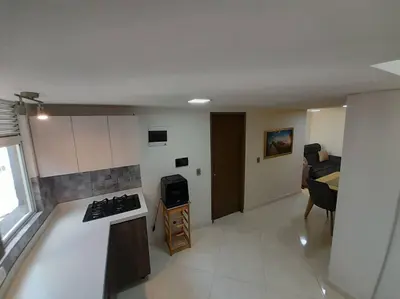 a kitchen with a stove top oven next to a living room at Dúplex con hermosa vista a la ciudad deck exterior in Itagüí