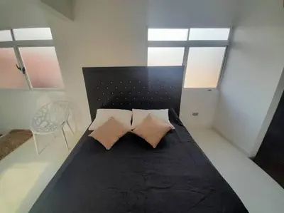a bedroom with a black bed with two pillows at Dúplex con hermosa vista a la ciudad deck exterior in Itagüí