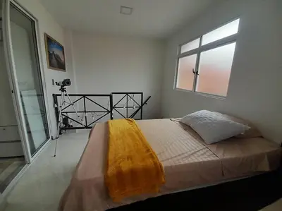 a bedroom with a bed with a yellow blanket on it at Dúplex con hermosa vista a la ciudad deck exterior in Itagüí
