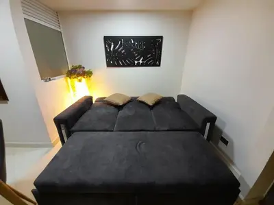 a black couch in a room with a table at Dúplex con hermosa vista a la ciudad deck exterior in Itagüí
