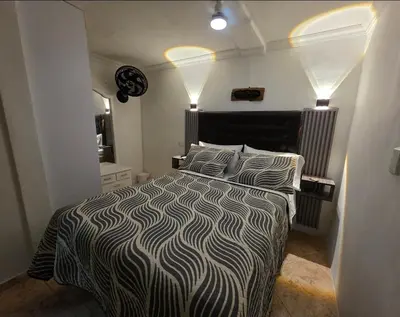 a bedroom with a bed with a black and white comforter at aparta-estudio cerca estación metro poblado in Belén