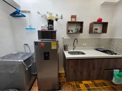 a kitchen with a sink and a microwave on top of a refrigerator at aparta-estudio cerca estación metro poblado in Belén