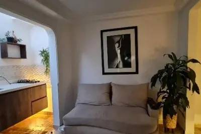a living room with a couch and a plant at aparta-estudio cerca estación metro poblado in Belén