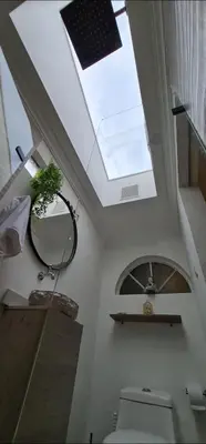 a bathroom with a toilet and a skylight at aparta-estudio cerca estación metro poblado in Belén