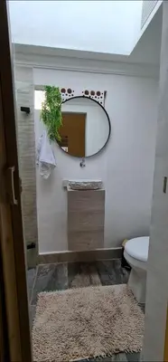 a bathroom with a mirror and a toilet and a rug at aparta-estudio cerca estación metro poblado in Belén