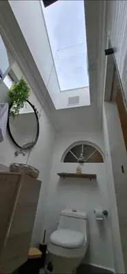 a bathroom with a toilet and a skylight at aparta-estudio cerca estación metro poblado in Belén