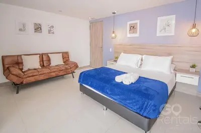 a bedroom with a bed and a couch at Charming Decor & Stunning Views Green Poblado in Medellín