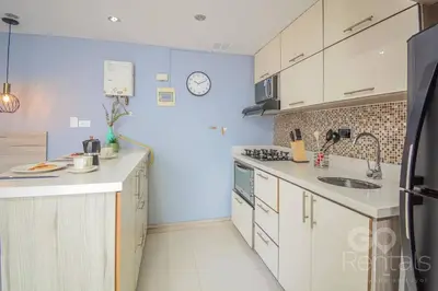 a kitchen with white cabinets and a clock on the wall at Charming Decor & Stunning Views Green Poblado in Medellín
