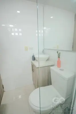a white bathroom with a toilet and a sink at Charming Decor & Stunning Views Green Poblado in Medellín