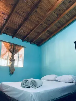 a blue bedroom with a bed with two towels on it at ByB Casa campestre in Riochico Pérez