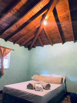a bedroom with a bed in a room with wooden ceilings at ByB Casa campestre in Riochico Pérez