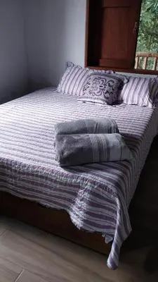 a bed with two pillows sitting on top of it at Caminos Alojamiento in Jardin