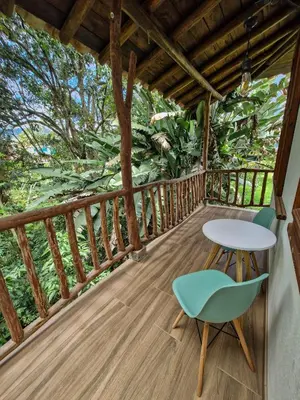 a wooden balcony with a table and chairs on it at Caminos Alojamiento in Jardin