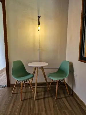 two chairs and a table in a room at Caminos Alojamiento in Jardin