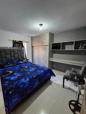a bedroom with a bed and a desk and a chair at Apartamento Super Exclusivo in Medellín